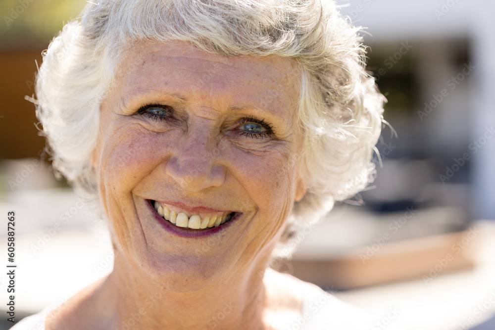 Portrait of happy senior caucasian woman looking at camera and smiling in sunny garden Portrait of happy senior caucasian woman looking at camera and smiling in sunny garden