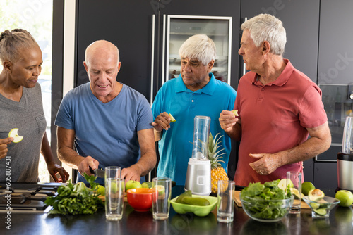Happy diverse senior friends discussing ingredients for preparing healthy smoothies in kitchen