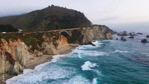 Aerial Cinematic drone early spring coastline Big Sur Rock Creek Bixby Bridge coastal Highway 1 cars vista point California early sunrise sunset morning rugged deep blue ocean forward pan motion photo