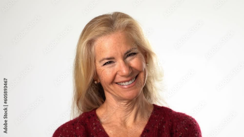 Close-up portrait view of the confident attractive smiling mature woman looking at the camera isolated on white background in studio Close-up portrait view of the confident attractive smiling mature woman looking at the camera isolated on white background in studio