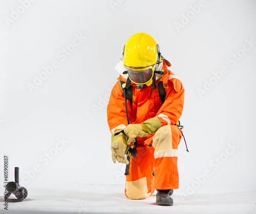 With focused intent the professional firefighter sits in a kneeling position carefully sliding their gloved hand into place, ensuring a snug and secure fit.