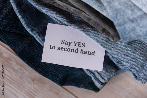 SAY YES TO SECOND HAND text on paper note on Jeans clothes assortment Second hand sustainable shopping. Capsule minimal wardrobe. Sustainable fashion overconsumption, conscious buying consumption
