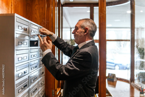 concierge opening the mailboxes of the residents of the building