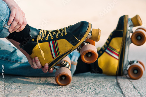 close up view of woman's hand arranging four-wheeled colored skates