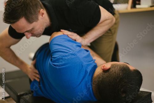 Patient receives a spinal adjustment at a chiropractic office photo