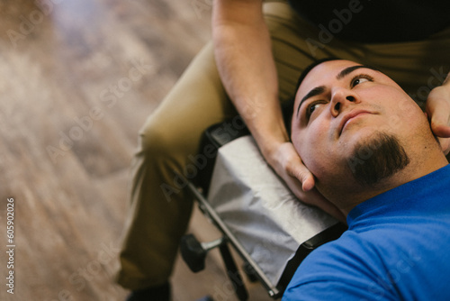 Obraz na plátně Latino patient gets neck adjustment from chiropractor