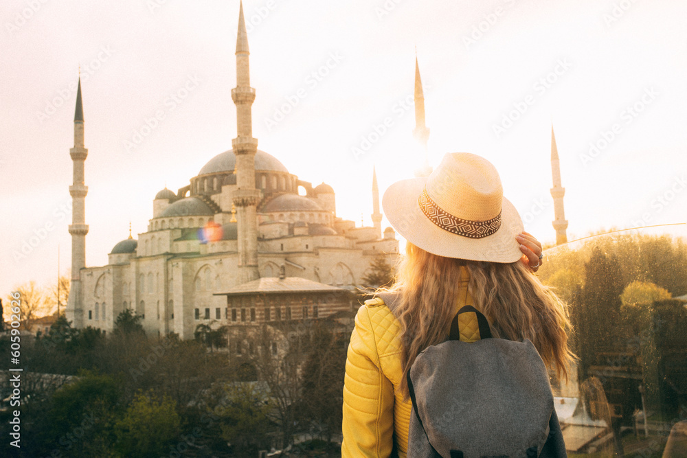 Fototapeta premium Young beautiful girl traveler in a hat with a backpack