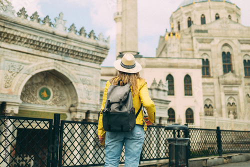Young beautiful girl traveler in a hat with a backpack