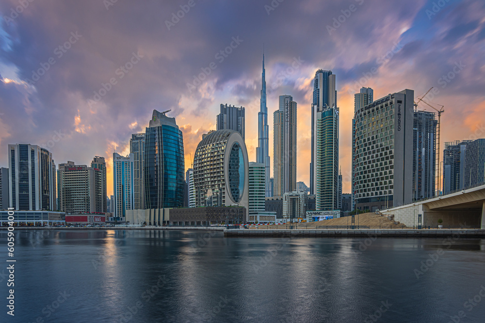 Mystical sunset with a cloudy sky over the skyline of the financial district in Dubai. Business center with office buildings and skyscrapers around Burj Khalifa. Street with a bridge over the harbor Mystical sunset with a cloudy sky over the skyline of the financial district in Dubai. Business center with office buildings and skyscrapers around Burj Khalifa. Street with a bridge over the harbor
