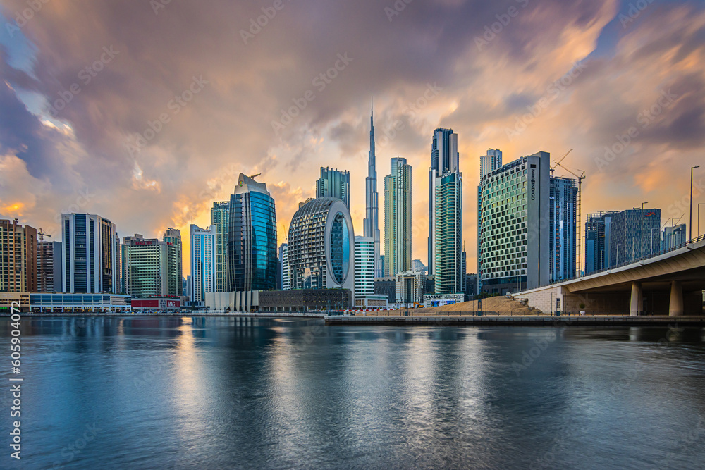 View of the Dubai skyline in the evening. Sunset over the skyscrapers with Burj Khalifa in the city's Marina Bay. Business center building and part of a bridge with streets