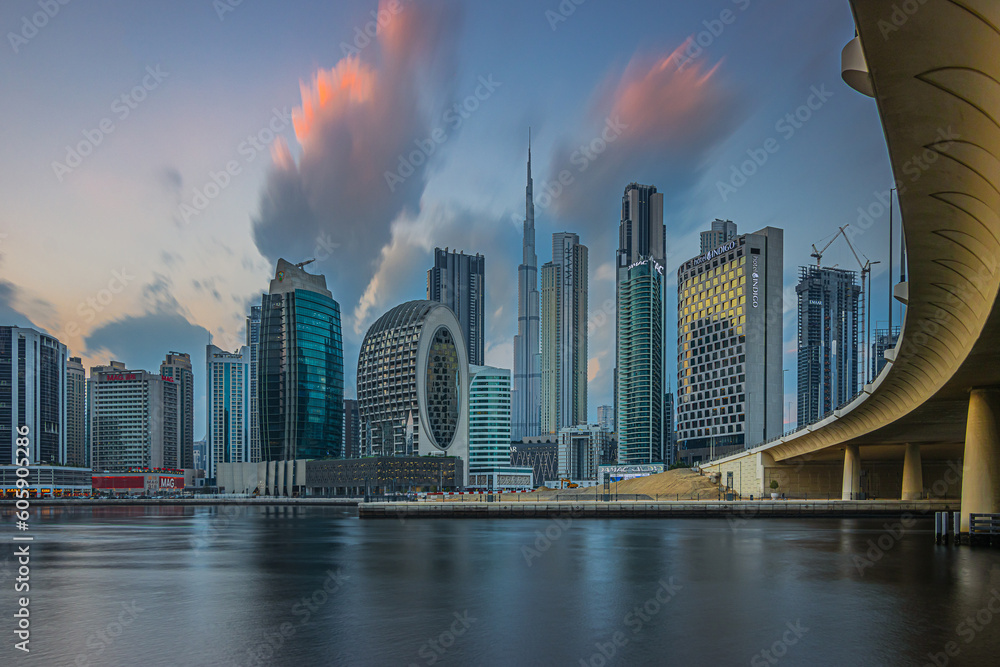 Skyscrapers of Dubai. City center skyline in the evening. Skyscrapers in the city of United Arab Emirates. Sunset with clouds over the skyscrapers.The course of the bridge over the port