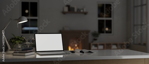 Laptop mockup with accessories on a tabletop in a cozy living room with fireplace at night.