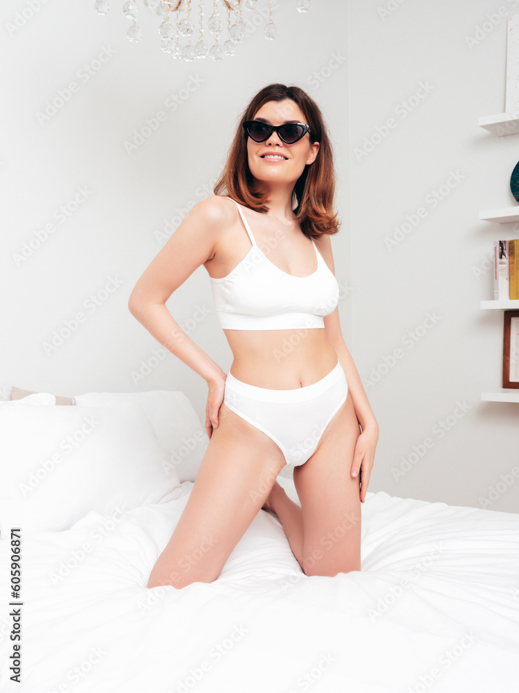 Attractive and relaxed seductive young woman with slim body wearing white underwear. Sexy smiling model lying in the bedroom at home in the early morning in lingerie. Happy female in bed. Sunglasses Attractive and relaxed seductive young woman with slim body wearing white underwear. Sexy smiling model lying in the bedroom at home in the early morning in lingerie. Happy female in bed. Sunglasses