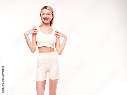 Young beautiful smiling blond female in summer cycling shorts clothes. Sexy carefree woman posing on white background in studio. Positive model having fun indoors. Cheerful and happy © halayalex