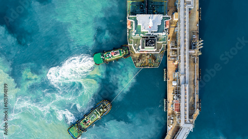Cuadro en lienzo Aerial view oil tanker ship at terminal industrial port tugboat drag crude oil tanker ship park to port for transfer crude oil to oil refinery, Global business import export transportation logistic