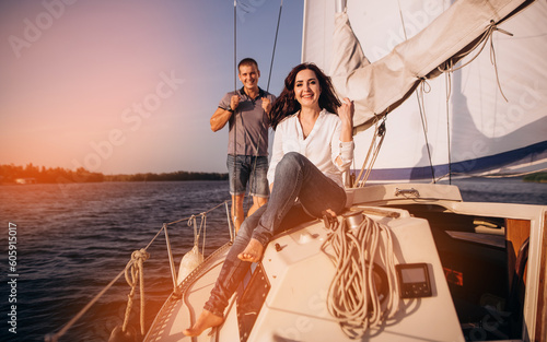 Portrait of cute loving couple hugging in the white boat at sunset. Summer vacation, love, kissing, honeymoon. Beautiful view, warm sunlight, blue water of sea. emotional man and woman. © VlaDee