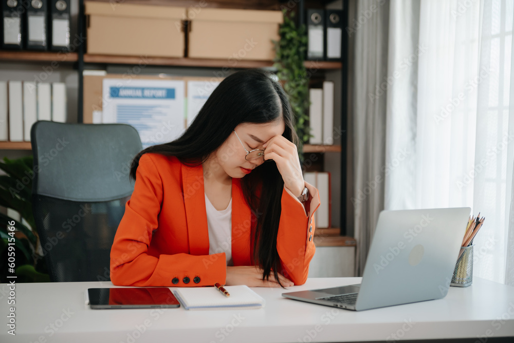 Overworked young Asian businesswoman office worker suffering from neck pain after had a long day at her office desk. Overworked young Asian businesswoman office worker suffering from neck pain after had a long day at her office desk.