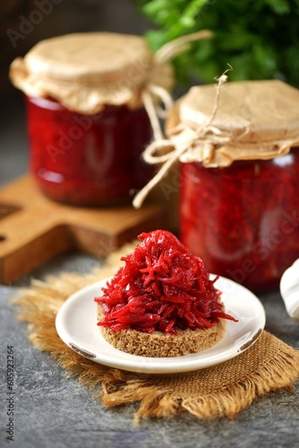 Homemade pikled appetizer of beetroot, carrots and onions on toasted bread and in jars. photo