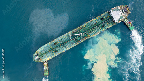 Aerial view oil tanker ship at terminal industrial port tugboat drag crude oil tanker ship park to port for transfer crude oil to oil refinery, Global business import export transportation logistic.