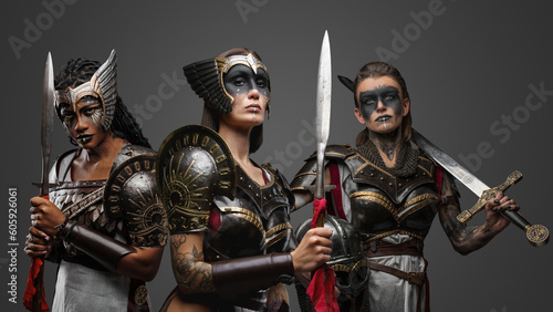 Portrait of three attractive female warriors dressed in iron armors.