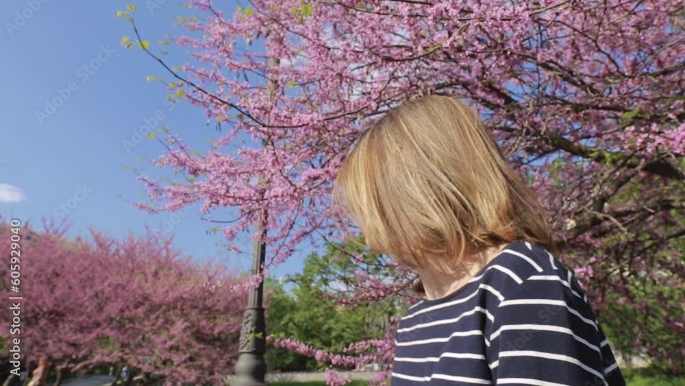 Video portrait middle aged woman in unglasses under the blooming sakura tree. Smiling, looking up aside and thinking. Video portrait middle aged woman in unglasses under the blooming sakura tree. Smiling, looking up aside and thinking.