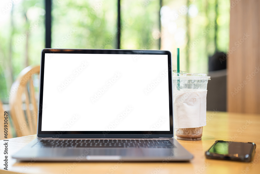 Mockup of laptop computer with empty screen with coffee cup and smartphone on table of the coffee shop background,White screen Mockup of laptop computer with empty screen with coffee cup and smartphone on table of the coffee shop background,White screen