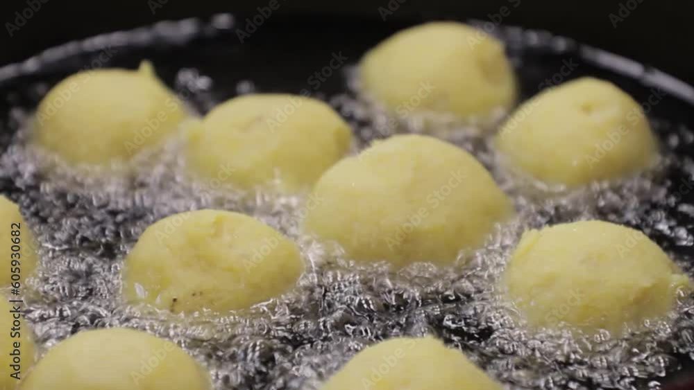 ripe banana balls with cheese filling in a friendose cauldron, view from above, dominican food. ripe banana balls with cheese filling in a friendose cauldron, view from above, dominican food.