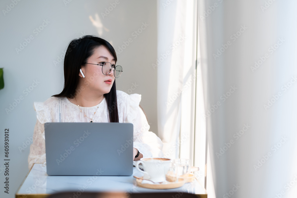 Happy of asian freelance people Businesswoman wearing wireless earphones casual working with laptop computer with a coffee cup mug,Notebook and smartphone at the cafe,Business Lifestyle communication Happy of asian freelance people Businesswoman wearing wireless earphones casual working with laptop computer with a coffee cup mug,Notebook and smartphone at the cafe,Business Lifestyle communication