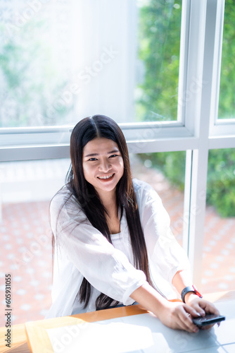 modern portrait of beautiful happy asian woman traveler wearing smartwatch wearing beautiful white dress and wear jeans lifestyle enjoying in sitting coffee shop restaurant background © Thinapob
