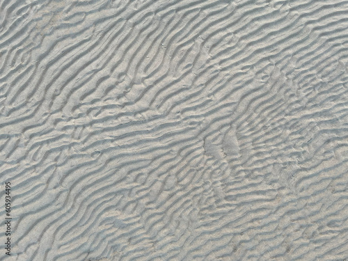 top view of a waved sand texture on the summer beach