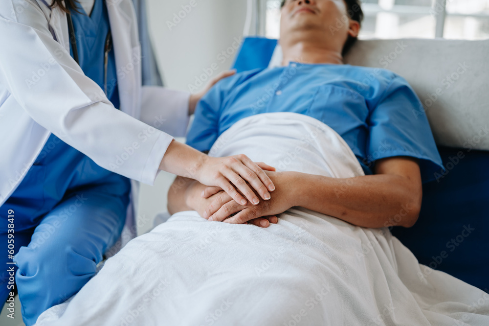 Female doctor holding male patient hand on the bed with receiving saline solution in hospital . Female doctor holding male patient hand on the bed with receiving saline solution in hospital .