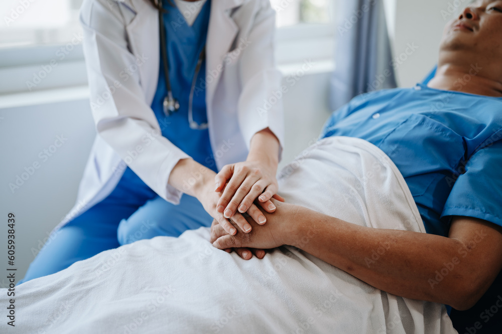 Female doctor holding male patient hand on the bed with receiving saline solution in hospital . Female doctor holding male patient hand on the bed with receiving saline solution in hospital .