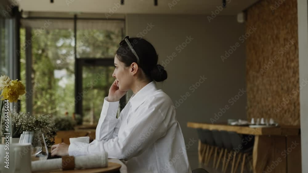 A pretty woman drinks coffee and enjoys an incredible view from the window to the Carpathian mountains in a restaurant A pretty woman drinks coffee and enjoys an incredible view from the window to the Carpathian mountains in a restaurant