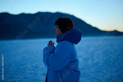 朝方,冬の山にいるショートヘアの女性 © One