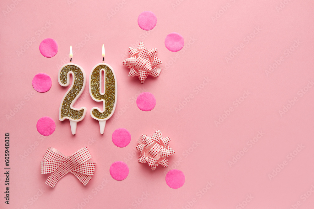 Number 29 on pastel pink background with festive decor. Happy birthday candles. The concept of celebrating a birthday, anniversary, important date, holiday. Copy space. Banner