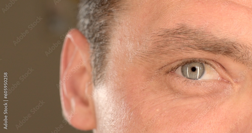 Fototapeta premium Close-up of the man's right eye. He blinks, looks at a point, the movement of the head. Humidification of the mucous membrane of the body.