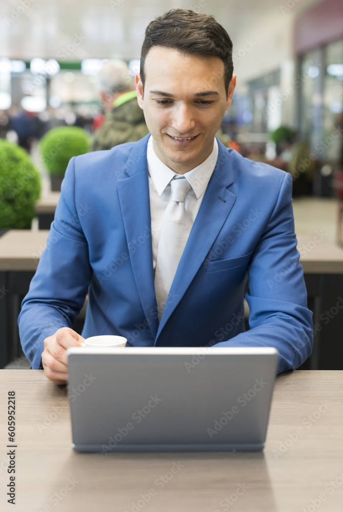 Detail of a businessman using a netbook in a cafe