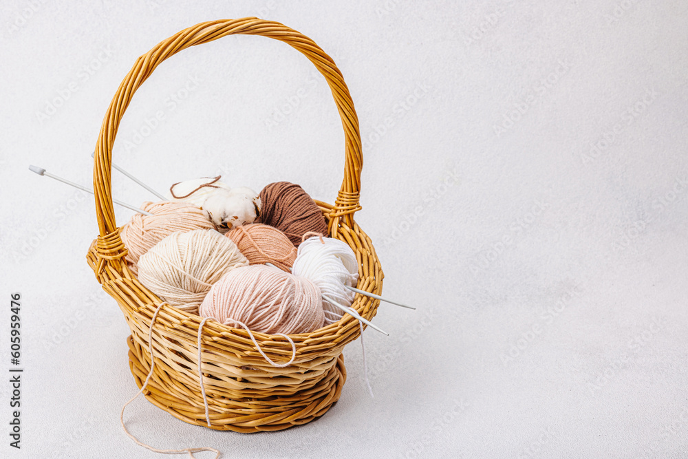 A set of pastel clew of thread for knitting in a basket. Handmade, hobby, crochet concept