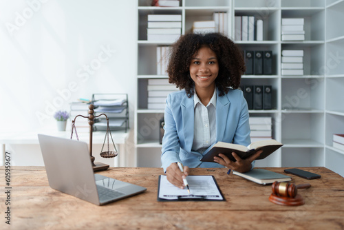 Young African American lawyer studying a case for a client and signing a legal contract to fight her opponent in court. Legal and lawyer concepts.