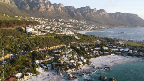 Scenic aerial view of beach in Cape Town, South Africa. Houses and villas on hill and table mountain in background.