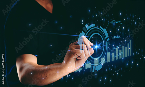 Businessman point to the futuristic hud of Big databases and business intelligence development with a hologram of the stock market graph for investment plans and corporate organization concept