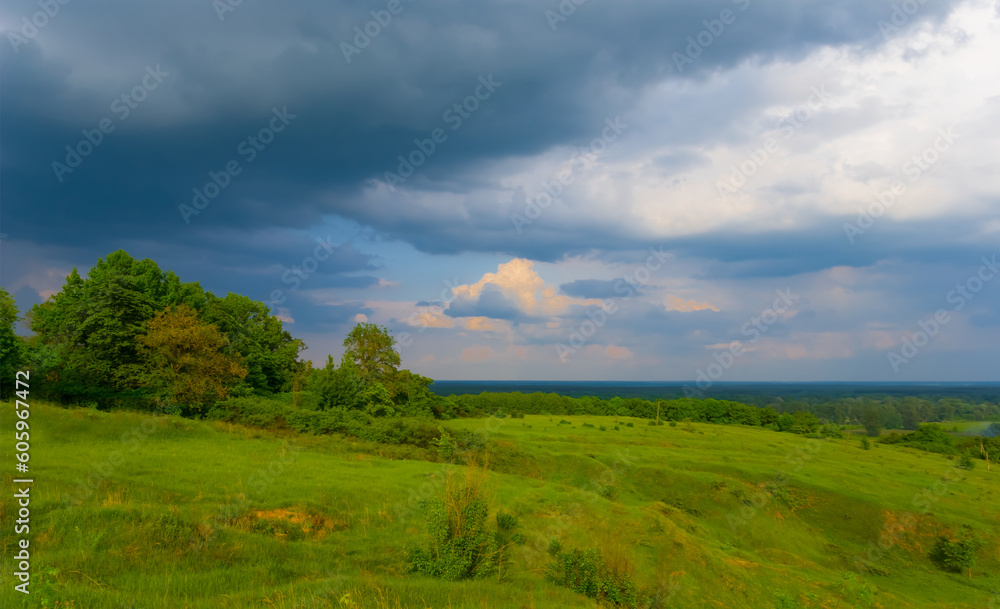 wide green  hills under dense cloudy sky