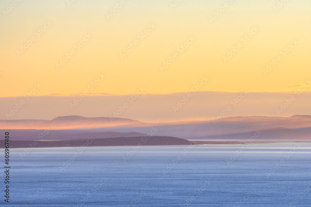 Morning seascape. View of the sea bay and hilly coast. Beautiful dawn landscape. Nature of Siberia and the Russian Far East. Travel, tourism and hiking in the Magadan region. Sea of Okhotsk, Russia.