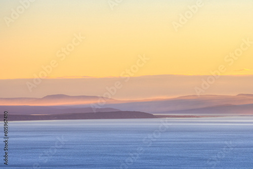 Morning seascape. View of the sea bay and hilly coast. Beautiful dawn landscape. Nature of Siberia and the Russian Far East. Travel, tourism and hiking in the Magadan region. Sea of Okhotsk, Russia.