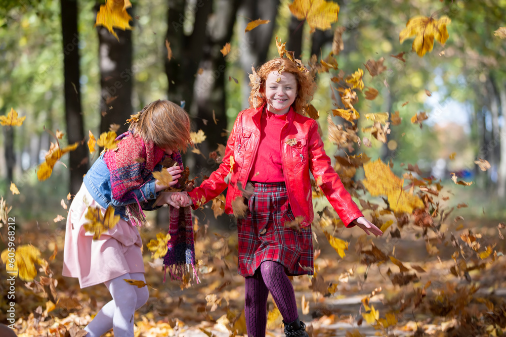 Happy children play in the autumn park on a warm sunny autumn day. Happy children play in the autumn park on a warm sunny autumn day.