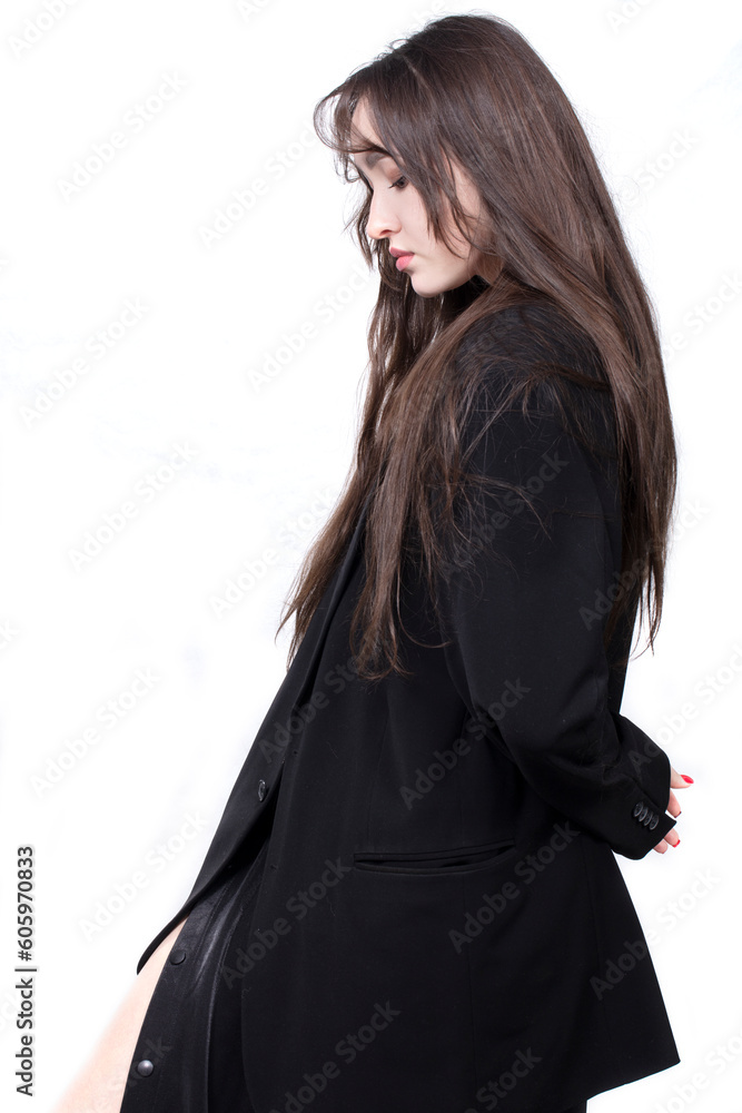 Profile portrait of a beautiful girl with long hair in a black jacket on a white background.