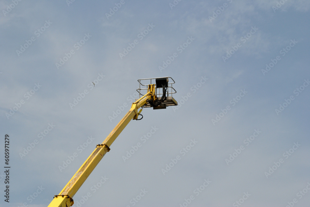 Extended Hydraulic Arm with Platform seen against Sky Extended Hydraulic Arm with Platform seen against Sky