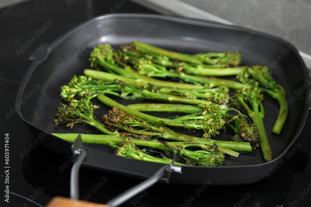 Grill pan with tasty cooked broccolini on cooktop, closeup Grill pan with tasty cooked broccolini on cooktop, closeup