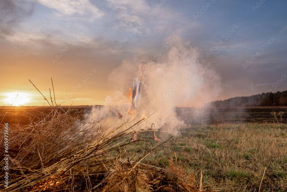 Obraz premium young guy crying in fire in burnt clothes, war, home destruction, human disappointment