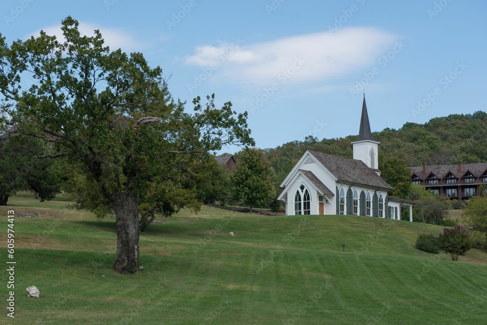 Chapel surrounded by trees under a cloudy blue sky Chapel surrounded by trees under a cloudy blue sky